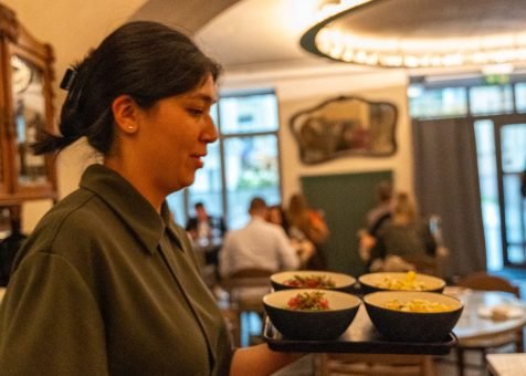 Augustin restaurant in Vilnius waitress with dishes to be served