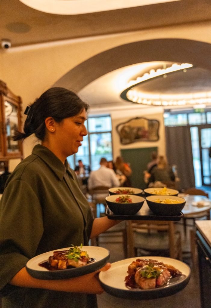 Augustin restaurant in Vilnius waitress with dishes to be served